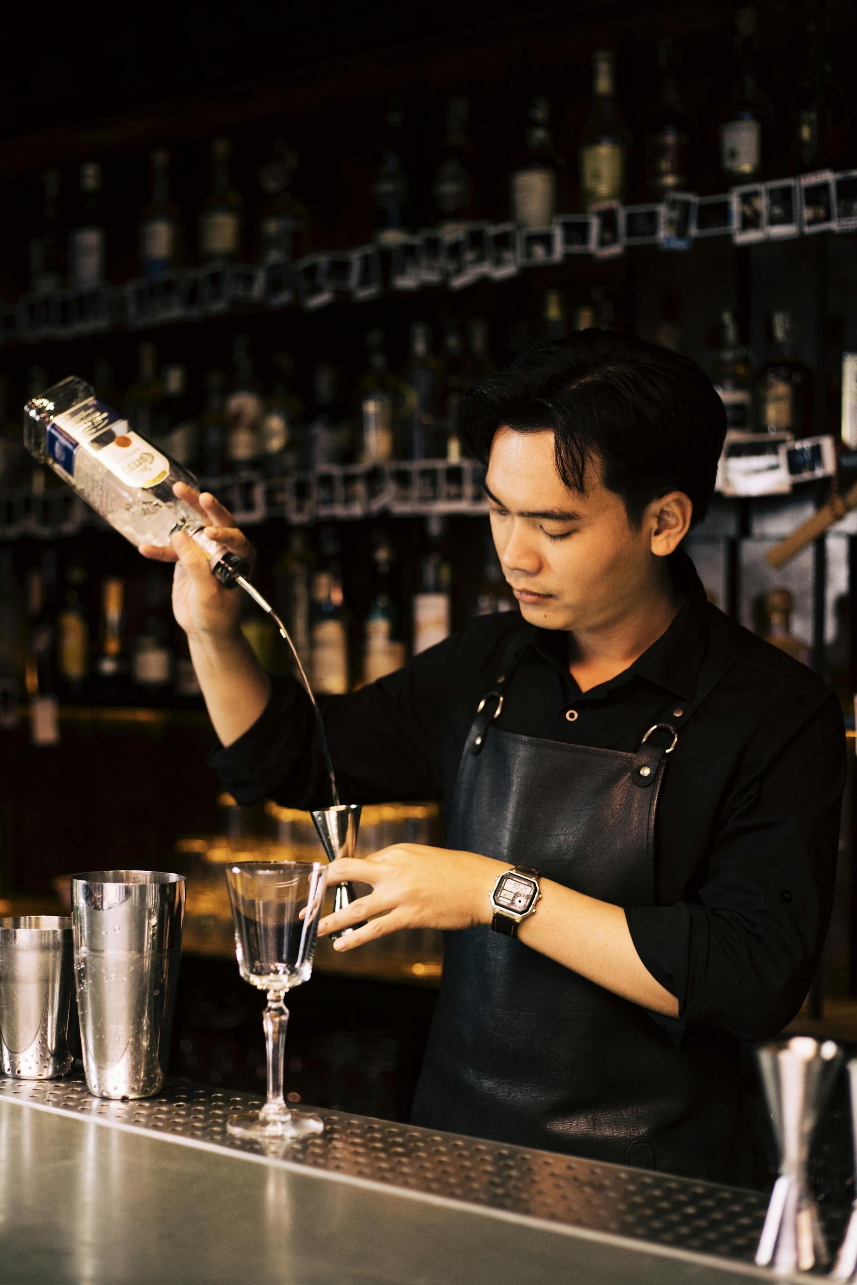 A bartender carefully pouring a cocktail at a pub in Da Nang, Vietnam.