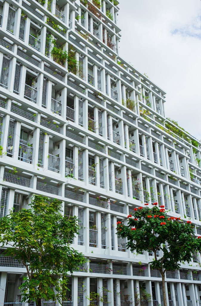 Contemporary building with lush greenery in Okinawa City, Japan under a cloudy sky.